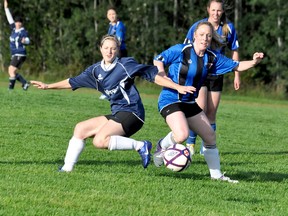 Aislynn Cooper, left, of Wolfepack Apparel & Designs, loses her balance after reaching back to stop the ball with her right foot, as Mabel Plourde-Doran, of Kapuskasing Eastview RV, charges through to take possession during the first half of Game 2 of Tuesday’s Timmins Women’s Soccer Club Series at Timmins High & Vocational School. Kapuskasing posted a 1-0 victory to take the best-of-three series 2-0.