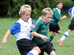 A Quinte West Bridge to Wealth U10 Wolverines player tries to fend off a Darlington Striker during semi-final action at the 17th annual Cameron Memorial Soccer Tournament, Sunday at Centennial Park.