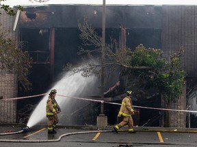 Ottawa firefighters clean up after an overnight fire at Argos Carpets in Ottawa on Wednesday. Tony Caldwell/Ottawa Sun