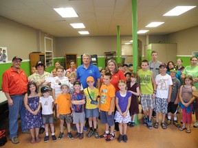 Members of the Boys and Girls Club of Gananoque crowd around during cheque presentation. In centre row, from left, is James Mailman of Home Hardware. His son, Robert, presents the cheque to Bradley Garrah, a club member. Brian Mabee of the Boys and Girls Club (in blue shirt) stands next to Home Hardware's Laura Ware.