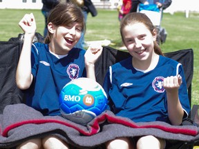 Two players from Scottish United U12 girls team posing with a ball they got from the Bank of Montreal. The Edmonton team is hoping to win BMO's Team of the Week contest. AMBER CLEASBY Photo Supplied