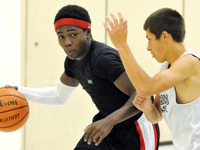 Isaac Gamble, left, is guarded by Shawn Sedlacek during a practice Sunday at the WISH Centre. They're on a Chatham-Kent basketball team playing this week at the International Children's Games in Windsor. (MARK MALONE/The Daily News)