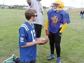 Brandon Diprose, left, and coach Stan Morrow give a few pointers to bantam quarterback Lincoln Jensen during practice Aug. 8.