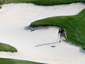 Tim Murphy fishes his ball out of a sand trap on the 16th hole at GlenEagles during the Cochrane and Area Humane Society’s Golf Tourney, Aug. 12.