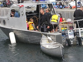 A dive boat pulls into the Portsmouth Olympic Harbour Wednesday morning after rescuing the occupants of two canoes that got caught up in stiff offshore winds and were being pushed out into the lake. Two other canoes and their occupants also had to be rescued.
Michael Lea The Whig-Standard