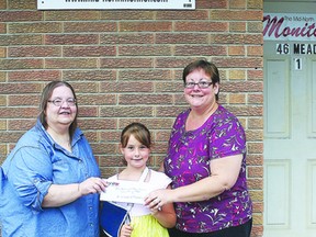 Helen Morley of the Mid-North Monitor presents the lucky winners with their tickets to Manitoulin Country Fest. Photo by Dawn Lalonde/Mid-North Monitor/QMI Agency