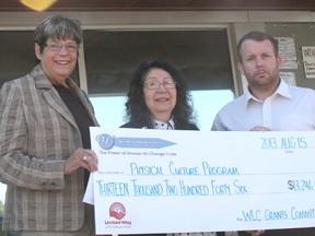 Gayle Stucke, president of the United Way’s Woman’s Leadership Council, left, presented a grant in the amount of $13,246 to Maxine Nahdee, acting chief for the Walpole Island Council, centre, and Darren Wood, youth programs coordinator with Chatham-Kent Community Health Centre (CKCHC), in front of the CKCHC office in Walpole Island, on Thursday August 15, 2013. The grant will fund a continuing program that promotes social inclusion among First Nations youth.  KIRK DICKINSON/FOR CHATHAM DAILY NEWS/ QMI AGENCY