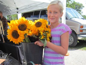 The Scotview Orchards booth at the Simcoe Farmers Market will be working overtime during the Mumford & Sons' concert weekend at the Norfolk County Fairgrounds Aug. 23-24. Looking forward to long hours helping out is Makayla VanBrugge of Scotland.  (MONTE SONNENBERG Simcoe Reformer)