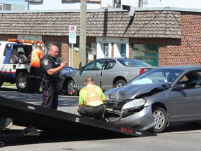 A tow truck driver hooks up a car involved in a two-vehicle collision at the corner of Davis and Brock streets Friday. Both Sarnia firefighters and paramedics were called to the scene after a vehicle heading westbound on Davis Street ran a red light and hit a vehicle travelling north on Brock Street around 11:10 a.m. One of the drivers was transported with minor injuries to Bluewater Health. Police have charged the westbound vehicle with failure to stop at a red light. BARBARA SIMPSON / THE OBSERVER / QMI AGENCY