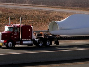 A flatbed transports wind turbine blades destined for the Port Burwell  area  down the 401 just east of London. (QMI Agency file photo)