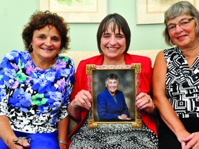 Sisters Danielle Pilon, left, Suzanne Dodge and Carole Hare pose with a picture of their mother, Madeleine Seguin, at the Brockville and District Hospice Palliative Care Service family room at the Brockville General Hospital Garden Street site (DARCY CHEEK/The Recorder and Times).