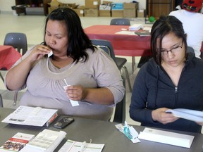 Stephanie Courtoreille, left,  swabs the inside of her cheeks so she can be entered as a donor on the Canadian Stem Cell Registry.