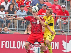 TFC's Justin Braun vies for the ball with Columbus Crew's Chad Marshall during a game earlier this season. (VERONICA HENRI/Toronto Sun)