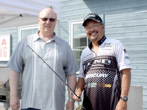Professional angler Ted Takasaki, right, accepted Krazy Krazy Audio and Video Warehouse owner Craig Salmson's, left, invitation to come to Timmins to celebrate the store's 25th anniversary on Friday. Takasaki will be back at Krazy Krazy on Saturday from 10 a.m. to 4 p.m. to talk fishing with local anglers.