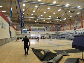 An employee walks through damage at the Syncrude Sport and Wellness Centre basketball court June 14. ANDREW BATES/TODAY STAFF