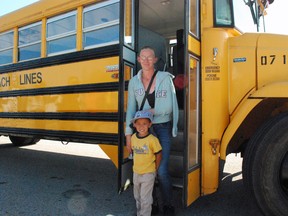 Doxsee Dewitt, age three, and mother Cordell stand outside a bus after Doxsee's first-ever school bus ride on Saturday, Aug. 17, 2013. The pair was taking part in a bus safety day at St. Joseph's Catholic High School in St. Thomas. Ben Forrest/QMI Agency/Times-Journal