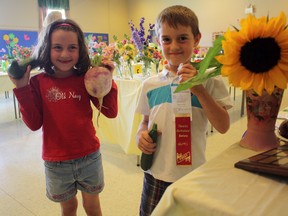 Young gardeners Nya and Brady Lindsay-Paul show off some of the winning vegetables from the 2013 Timmins Horticultural Society Summer Flower and Vegetable Show. In fact, Brady claimed the first-prize ribbon in the 6-9 age bracket for his zucchini-growing skills.