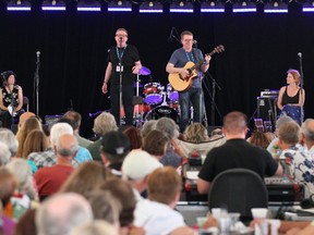 Maria Dunn, left, and Kathleen Edwards, right, look on as the Proclaimers, brothers Craig, left, and Charlie Reid, right, perform at the Down By The Bay tent at  the 38th Annual Summerfolk 2013 Music and Crafts Festival at Kelso Beach in Owen Sound on Saturday, August 17, 2013. (The Sun Times/JAMES MASTERS/QMI Agency)