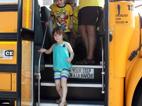 The brother-sister combination of Lukas and Ella Demers emerges from a school bus during the 2013 Bus Buddies Young Riders Day program at École catholique St-Dominique on Saturday morning.