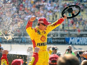 Joey Logano, driver of the No. 22 Shell-Pennzoil Ford, celebrates in Victory Lane after winning the NASCAR Sprint Cup Series Pure Michigan 400 at Michigan International Speedway on Sunday. (Getty Images/AFP)