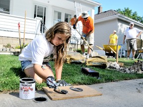 Kierra Kuipers, 9, paints the house numbers for Liz Huff's home during the fifth annual Backyard Mission Project which brings together volunteers from the First Presbyterian and First Christian Reformed churches and helps a local homeowner in need with home repairs. PHOTO TAKEN: Chatham, On., Saturday August 17, 2013. Diana Martin/Chatham Daily News/QMI Agency