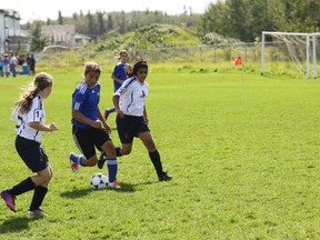 Lyndsey Janes dribbles the ball between two players from the Edmonton Drillers U12 team Saturday.

Robert Murray/Today Staff