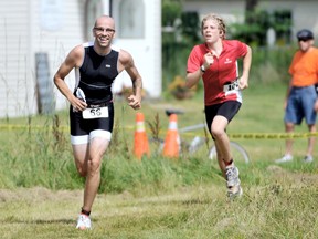 Abe Oudshoorn, 31, of London, breaks into a wide grin as he approached the finish line of his first triathlon, pursued by Dan Stein, 16, of Sydney, Australia, who was participating in his first Canadian race at the Chatham-Kent YMCA Triathlon at Rondeau Provincial Park Sunday. PHOTO TAKEN: Rondeau Provincial Park, Sunday August 18, 2013.  (Diana Martin/Chatham Daily News/QMI Agency)