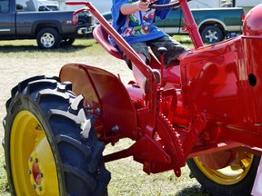 ight-year-old Matthew Yule tests out the 1949 restored Massey-Harris Pony while walking through tractor portion of the 20th annual Heritage Steam Show on Saturday, August 17, 2013 at the Heritage Farm in Paisley.