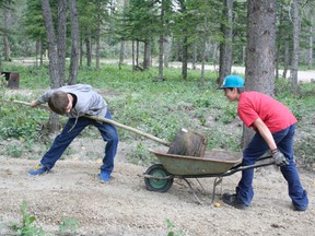 It was a day of planting Aug. 15 at EPBR’s Educational Forest. Jonah Doll (left) and  fellow volunteer Ted Beisel transport one of the trees to be planted in the educational forest.