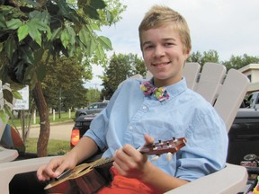 Aidan Wollard strums his ukelele on the McDonald family’s Polynesian float while waiting for Darwell’s 70th Annual Summer Fair (1944 - 2013) parade to get underway.