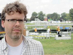 Jason Grant, spokesperson for Live Nation, fielded questions Monday on the set-up for the big Gentlemen of the Road concert this weekend in Simcoe. In the background, a crew from San Diego erects the stage in a construction zone on the grandstand infield at the Norfolk County Fairgrounds. (MONTE SONNENBERG Simcoe Reformer)