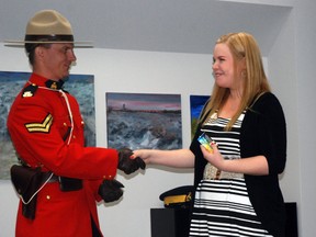 Cpl. Roy Kennedy with Grande Prairie RCMP presents Jackie Kirk with the first ticket of Crime Prevention's newly revived "positive ticket intiative" during the proclamation of Crime Prevention Week in May. Kirk, a Grade 12 student in the city, does a lot of volunteer work with Crime Prevention. The initiative allows certain members in the community to honour the good work being done by youth through a ticket system that then allows them to collect prizes. Since the launch, the program has been going well. (DHT file photo)