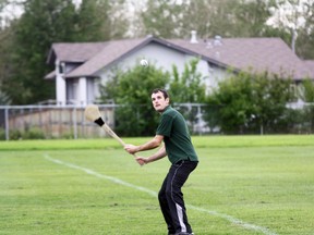 Brendan Kenny throws the ball in the air as he swings his hurley Friday night at Westwood Field. ROBERT MURRAY/TODAY STAFF