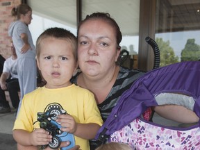 Eileen Tirone with her three-year-old son Anthony and eight-month-old daughter Nevaeh are being put up at the Days Inn in Brantford following a fire at 28 Helen Ave. on Friday, Aug. 16, 2013. A landlord representative told them Monday their leases are being terminated and they have the option of taking other units the landlord has available, or will be given back their last month's rent.(BRIAN THOMPSON The EXPOSITOR)