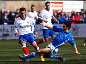 Montrose's Terry Masson tackles Rangers' Ian Black during their Scottish Third Division soccer match March 30, 2013. (REUTERS/David Moir)