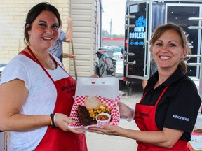 Katie Vander Velde (left) and Pauline Wood show off a plate of the Kinsmen Corn Stars Ribs, one of four vendors selling ribs during Ribfest, Aug. 17.
