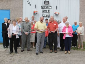 Mayor Peter Politis  cuts the ribbon for the Second Mile Club's grand opening last Thursday while the club's president, Gordon Wright (center) and two of it's oldest members Isabelle Shier (left) and Ethel Alexander (right) hold the ends.