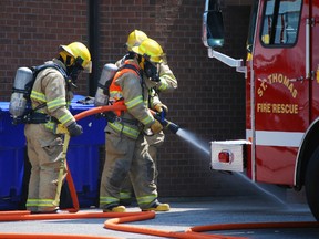 New St. Thomas firefighter Andrew Murray (orange vest) participates in a training exercise at the main fire station on Wednesday. The exercise simulated conditions in a house fire.