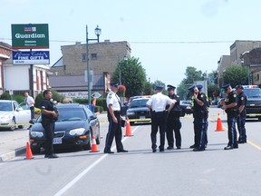 Middlesex OPP officers confer at the scene of an accident in Glencoe Thursday where one person was killed and another seriously injured.