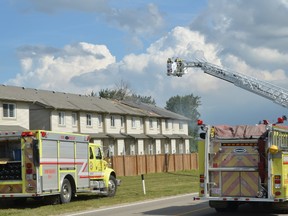 Firefighters cut a hole in the roof of this housing complex in order to vent the flames and prevent gasses from building up while fighting a fire on Aug. 17 in the Silverstone neighbourhood in Stony Plain. - Thomas Miller, Reporter/Examiner