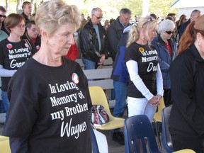 Faye Voisey stands during a moment of silence at last September's Walk to Remember Victims of Asbestos held at the Dow People Place in Sarnia's Centennial Park. This year's walk and vigil will be held Sept. 14 in the park. (File photo)