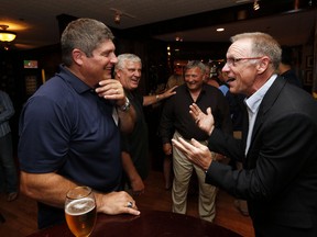 Lineman Dan Ferrone (left) and assistant coach Dennis Meyer reminisce during Thursday night’s Argos reunion. (MICHAEL PEAKE/Toronto Sun)