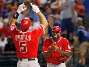 Los Angeles Angels' Albert Pujols (left) and Torii Hunter celebrate after scoring on Pujols' home run against the Texas Rangers during their American League game in Arlington, Texas August 1, 2012. (REUTERS/Mike Stone)