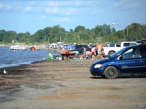 Beachgoers are pictured at the West Ipperwash Beach Saturday. Kettle and Stony Point First Nation members are hoping to introduce fees at the beach next year, part of an effort to clean the area and create jobs for locals. Information pamphlets were handed out at the beach Saturday. TYLER KULA/ THE OBSERVER/ QMI AGENCY