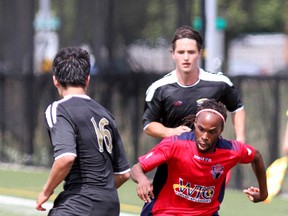 Kingston FC's Edgar Soglo battles for the ball with  North York Astros Vasas FC's Jungwon Jung (16) and Erik Gulyas on Sunday at Queen's West Campus field. (Ian MacAlpine The Whig-Standard)