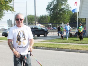Gary Coombs takes Pickle and Buster for a walk for the first annual Seaforth Dog Walk and Silent Auction, raising money for the Bow Wow Rescue in Clinton on Sunday evening.
