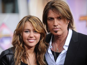 Singers Miley Cyrus (L) and her father Billy Ray Cyrus. (REUTERS/Phil McCarten/Files)