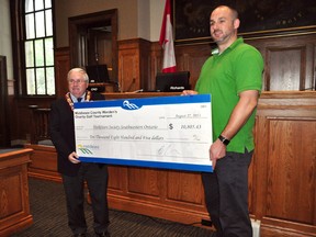 Middlesex County Warden Brad Richards presents a donation to Jeremy McCall, Special Events Coordinator, Parkinson Society Southwestern Ontario, inside the Middlesex County Building in London August 27, 2013. The annual Warden’s Charity Golf Tournament recently raised $10,805 for the Parkinson Society. CHRIS MONTANINI\LONDONER\QMI AGENCY