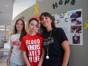 Stephanie Simmons, a three-time brain tumour survivor, seen here with her mother and sister, kicked off the Gold Ribbon Campaign Aug. 28, 2013 in London, Ont. at the Canadian Blood Services' London Blood Donor Clinic on Wharncliffe Road South. The province-wide campaign is seeking 1,700 people to donate blood during national Childhood Cancer Awareness Month this September. SHOBHITA SHARMA/LONDONER/QMI AGENCY