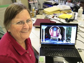 Kingston artist Cathie Hamilton shows a photo on her computer of the Roma gypsy wagon she painted over the summer. She researched the Roma culture to discover the designs she could use. (Michael Lea The Whig-Standard)